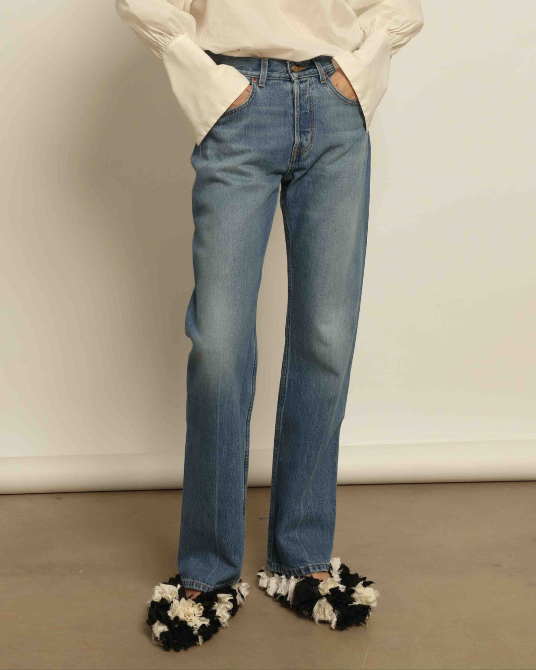 Model is wearing the Tilda Mid-Rise Draped Straight Jean by B Sides in classic indigo denim, mid-rise fit with straight tapered leg and curved inseam for a leg-lengthening silhouette.