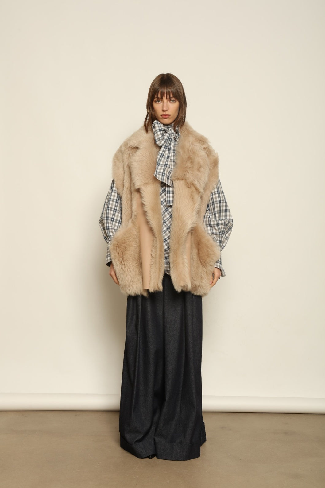 Model is wearing the Toscana Sabbia Shearling Vest by Blancha – a 100% Toscana sheepskin vest made in Italy, featuring a soft natural texture, warm drape, and refined Sabbia tone, styled for effortless layering and timeless elegance.