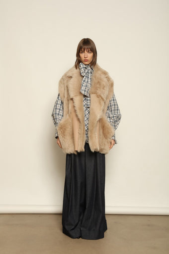 Model is wearing the Toscana Sabbia Shearling Vest by Blancha – a 100% Toscana sheepskin vest made in Italy, featuring a soft natural texture, warm drape, and refined Sabbia tone, styled for effortless layering and timeless elegance.