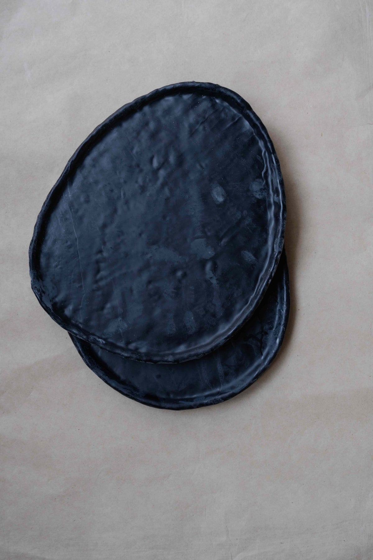Tray Oval in Black by Oberflacht, part of the House of Nomad Stories selection, handcrafted from beeswax and paraffin with smooth matte finish and unique variations in colour and texture.