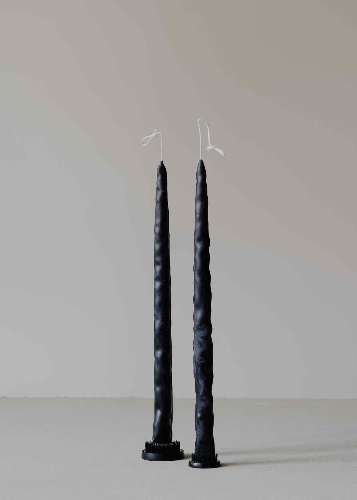 Twig Pair in Black by Oberflacht, part of the House of Nomad Stories selection, handcrafted from beeswax and paraffin with slender shape, deep black hue, and subtle variations in form and texture.