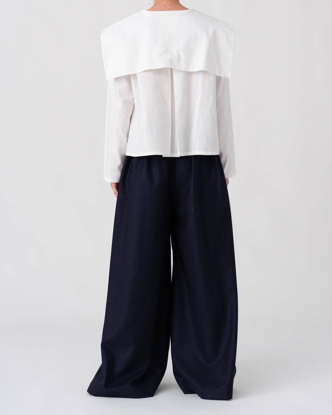 Model is wearing the Wool Black Pantalons by Les Vacances d’Irina, wide-leg handmade jersey-knit wool pants with adjustable drawstring waist and side pockets, available at House of Woven Stories.