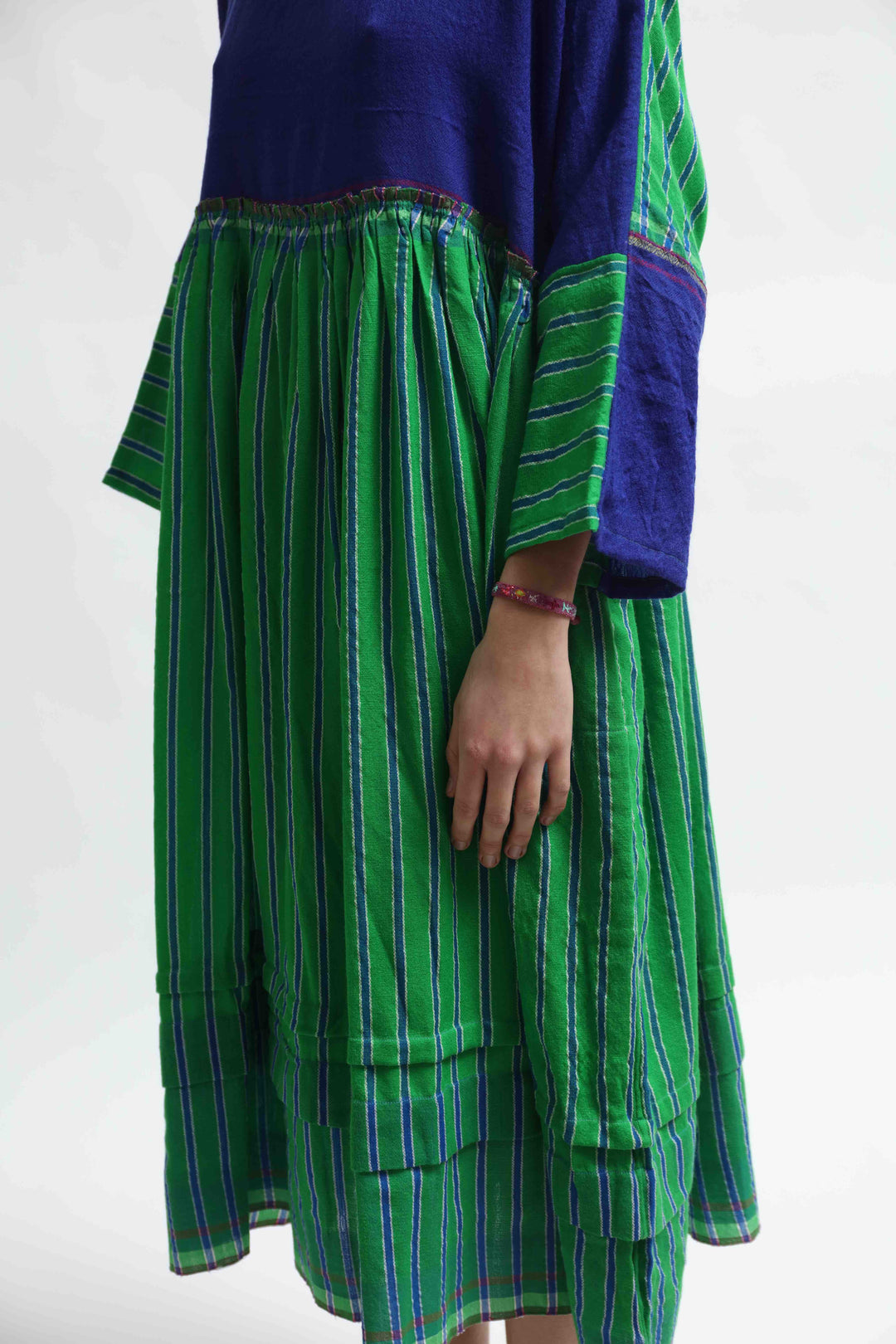 Model wearing the Injiri Wool Midi Dress, handcrafted in India in rich indigo and green tones with a contemporary striped detail, curated by House of Nomad Stories.