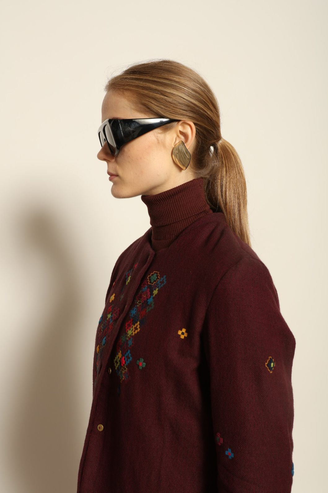 Model wearing the Miraj 195 Jacket by Injiri, handwoven from maroon wool and silk with intricate Jamdani motifs, curated by House of Nomad Stories.